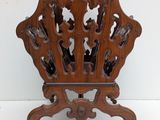 a wooden magazine rack with a carved design on it