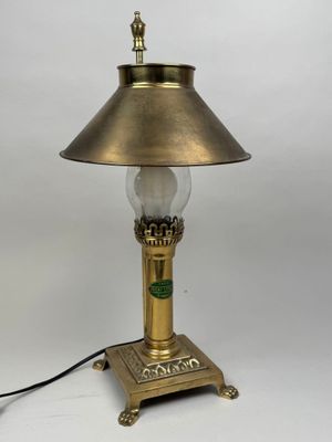 une lampe de table ancienne en laiton, surmontée d'un abat-jour en verre