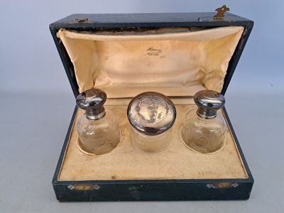 three glass bottles in a case with a clock in it