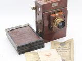 a small wooden box with a camera and some papers