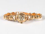 une photo d'une montre-bracelet pour femme posée sur une surface blanche