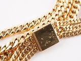 an image of a close up of a gold chain with a watch on it