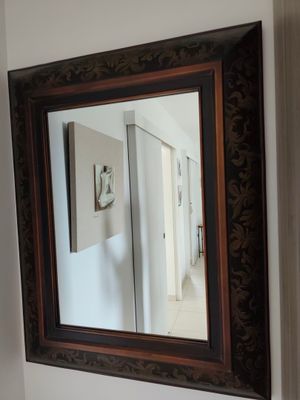 un miroir sur le mur au-dessus d'un lavabo dans une salle de bains