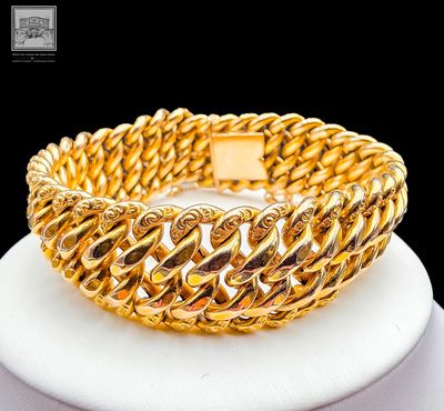 gold plated bracelet on a white plate with a black background