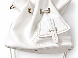 the white purse is hanging on the wall on the wall