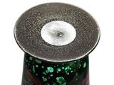 a black vase with a green and red design on it