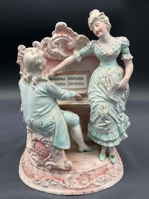 a figurine of a woman and a child playing a piano