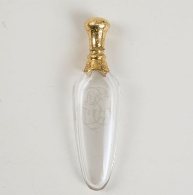 une image représentant une bouteille en verre avec une poignée dorée