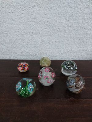 five glass marbles sitting on a table next to each other