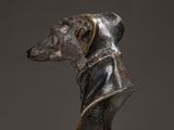 a bronze statue of a dog wearing a leather jacket