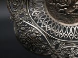 a silver plate with a design on it on a table