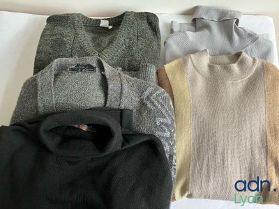 four sweaters are laid out on a white surface with a logo on the back