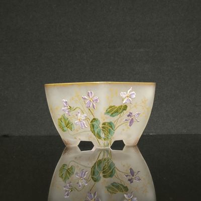 un bol blanc orné de fleurs violettes, posé sur une table