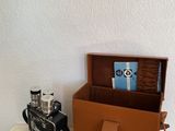 une boîte contenant un appareil photo et un livre, posée sur une table