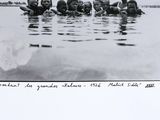 black and white photograph of a group of children swimming in the water