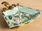 a small green and white bowl with a bird on it