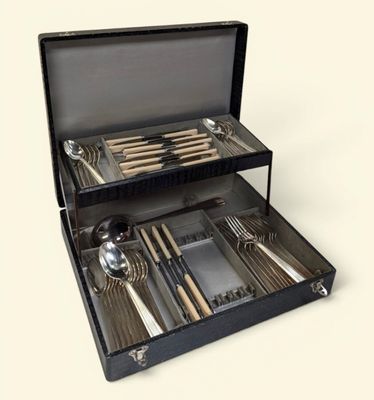 un coffret noir contenant de l'argenterie, sur fond blanc