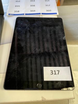 une tablette posée sur une table, à côté d'une boîte