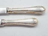 two silver spoons sitting next to each other on a table