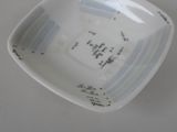 a small white bowl with writing on it sitting on a table