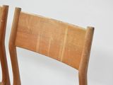 two wooden chairs that are sitting next to each other