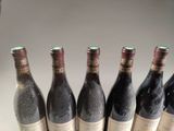 six bottles of wine are lined up in a row on a table