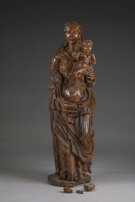 a wooden statue of a woman holding a child