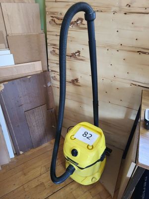 un aspirateur jaune posé sur un parquet