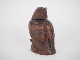 carved wooden owl figurine sitting on top of a white surface