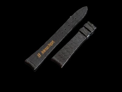 un bracelet de montre noir et un bracelet de montre noir sur fond noir