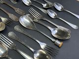 a lot of silver spoons and forks on a table