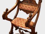 une chaise en bois dont l'assise est recouverte d'un tissu rouge et doré