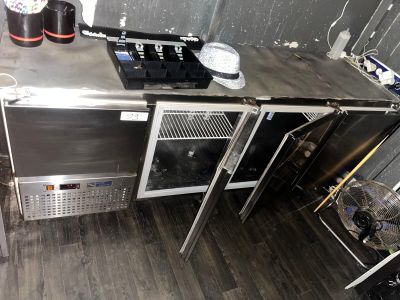 une cuisine avec de nombreux appareils électroménagers en inox posés sur le plan de travail