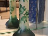 two green vases sitting on a shelf next to a mirror