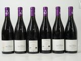 six bouteilles de vin sont alignées sur une table