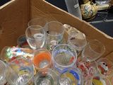 a cardboard box full of empty glasses on the floor