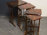 trois tables en bois ornées de motifs différents dans une pièce