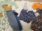 several children ' s clothing items are laid out on a table