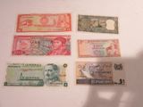 five different bank notes on a white surface