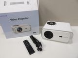 a box with a projector and a remote on the table