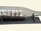 a ship in a glass bottle on a metal stand