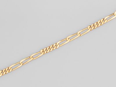 a close up of a gold chain on a white background