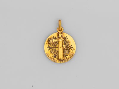 un pendentif plaqué or représentant un arbre et un oiseau