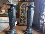two black vases sitting on a carpet in a room