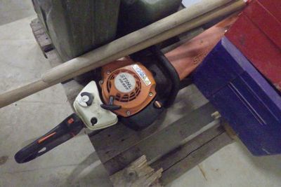 une tronçonneuse posée sur une palette dans un garage