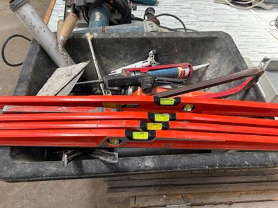 de nombreux outils qui traînent dans une boîte posée par terre