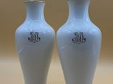 two white vases sitting next to each other on a table