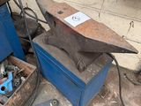an old anvil sitting in a box next to a blue box