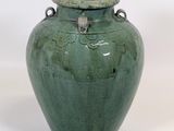 a green vase that is sitting on a white surface