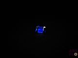 une image représentant un anneau bleu dans l'obscurité, éclairé par une lumière